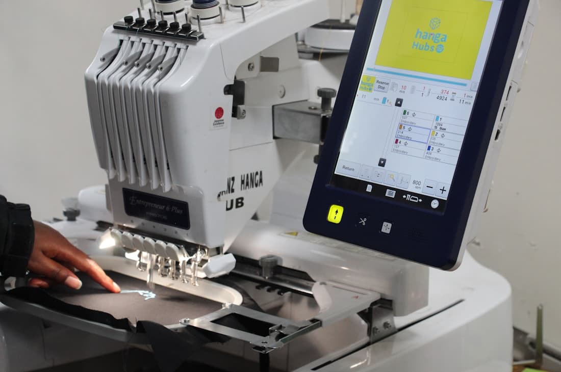 An operator running a multi-needle embroidery machine